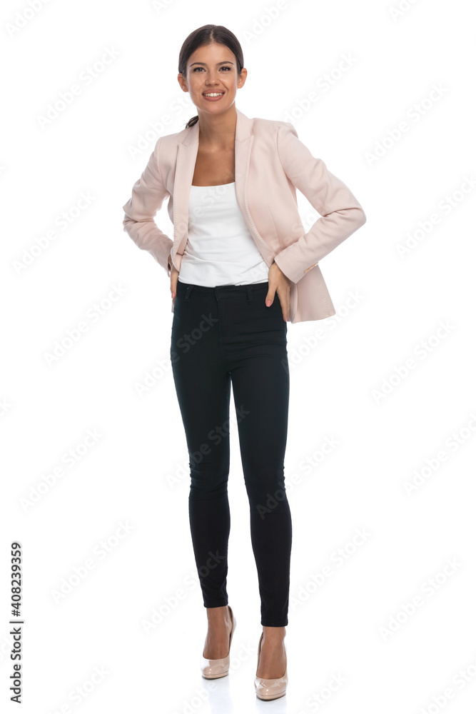 brunette smart casual woman in pink jacket holding hands on hips brunette smart casual woman in pink jacket holding hands on hips