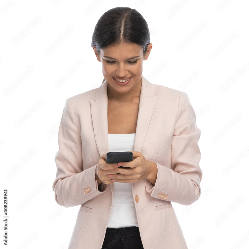 attractive young woman in pink jacket writing emails and smiling attractive young woman in pink jacket writing emails and smiling