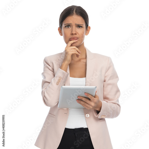 confused sexy businesswoman holding tab and wondering