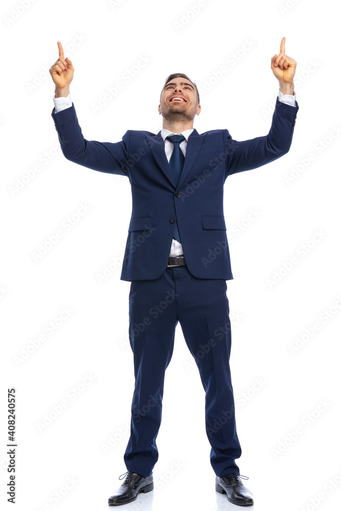 young elegant guy in suit pointing fingers in the air and smiling young elegant guy in suit pointing fingers in the air and smiling