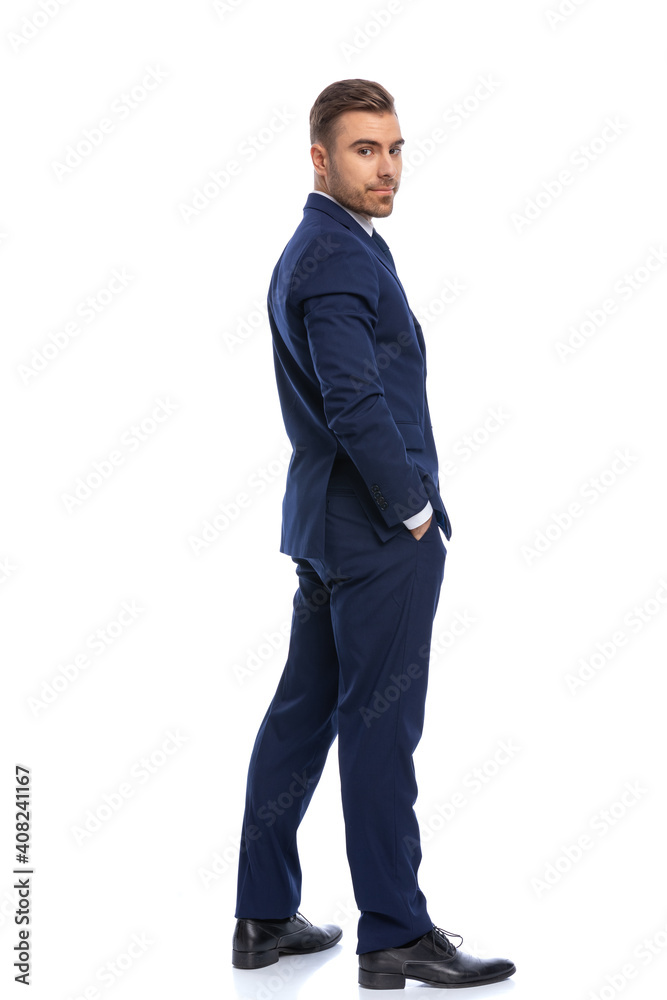 happy young guy in navy blue suit holding hands in pockets happy young guy in navy blue suit holding hands in pockets