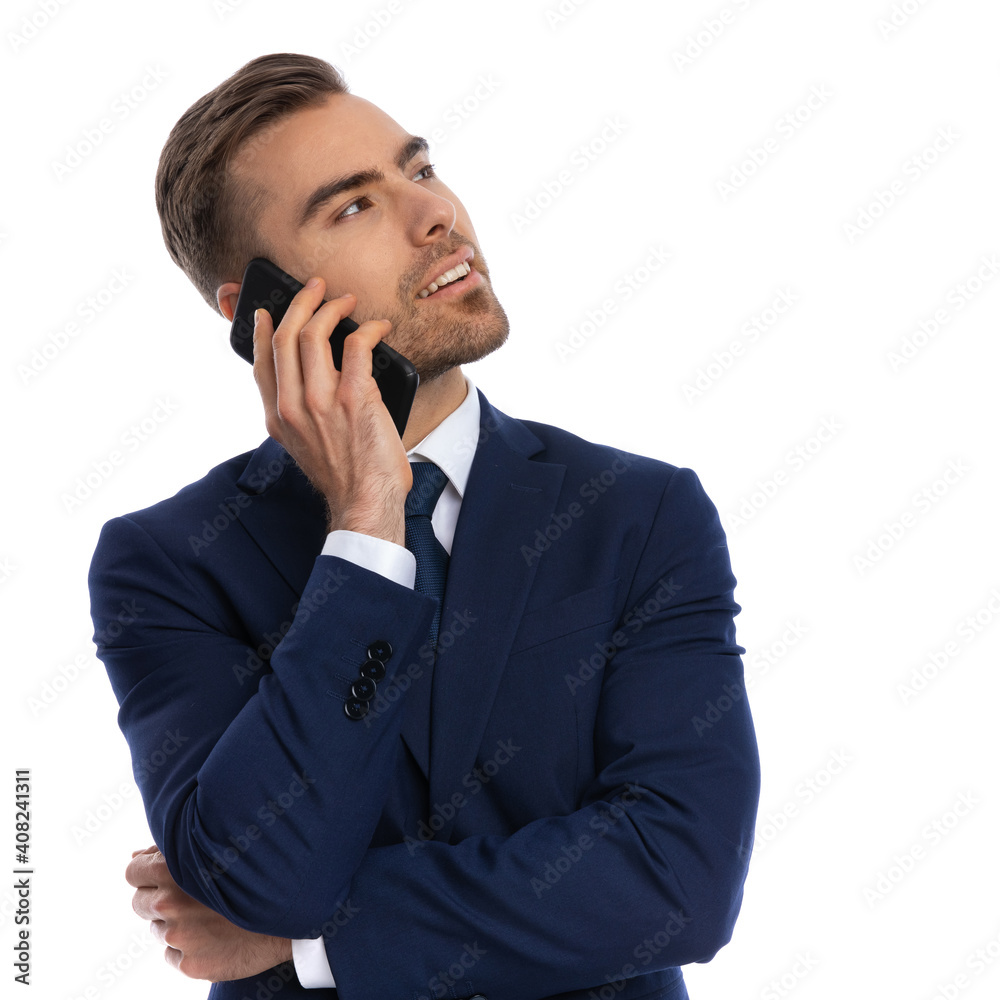 elegant young businessman looking up and talking on the phone elegant young businessman looking up and talking on the phone