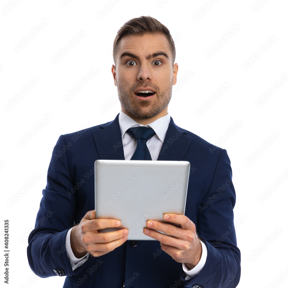 surprised young guy in suit holding tab and reading messages surprised young guy in suit holding tab and reading messages