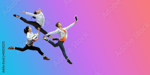 Juicy. Happy office workers jumping and dancing in casual clothes or suit isolated on gradient neon fluid background. Business, start-up, working open-space, motion, action concept. Creative collage.
