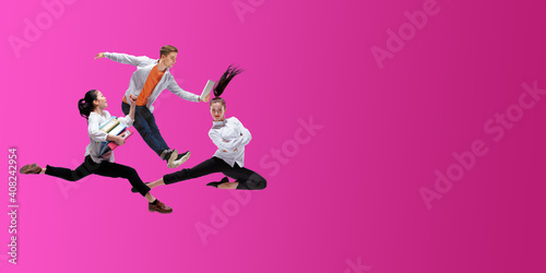 Strawberry. Happy office workers jumping and dancing in casual clothes or suit isolated on gradient neon fluid background. Business  start-up  working open-space  motion  action concept. Creative