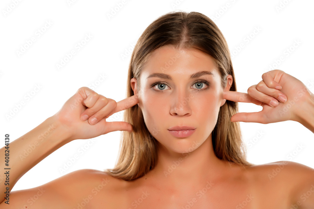 a young beautiful woman with blue eyes closes her ears with her fingers a young beautiful woman with blue eyes closes her ears with her fingers