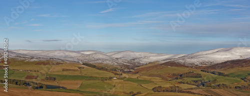 A Scottish Landscape of the Angus Glens looking towards Glen Esk, with snow on the tops of the Hills above the Farms on the lower slopes. © Julian