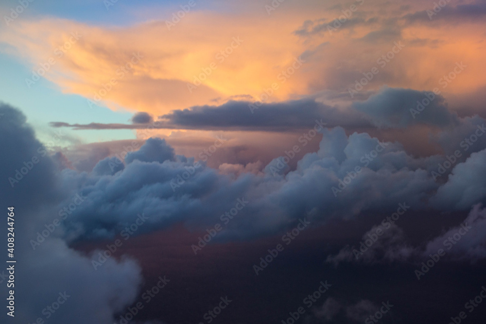 Naklejka premium spectacular sunset seen from an airplane with clouds in the foreground and in the distance 