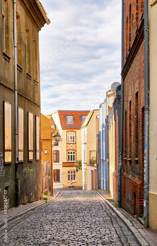 Narrow cobblestone alley on the street and old houses in the old town of Wismar.