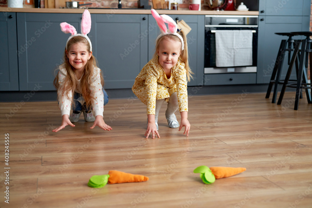 Fototapeta premium Two little girls playing handmade carrots on the floor