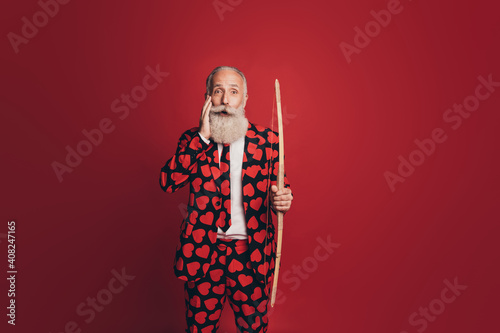 Photo of shocked funny man hold bow palm cheek open mouth wear heart print tuxedo isolated red background