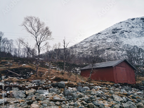 Old wooden house on a slippery rocky hill on the island of Kvaloya in Tromso, Norway photo