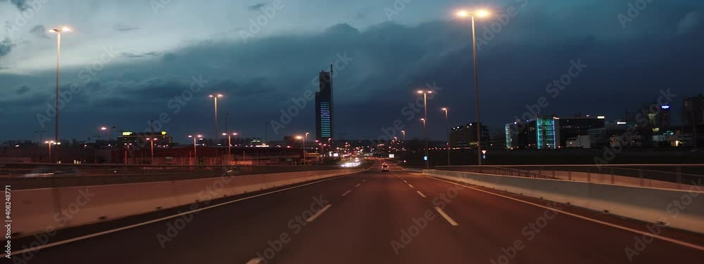 Night driving on multiple lane road in town. Low traffic at city ring after sunset. Car driver's point of view.