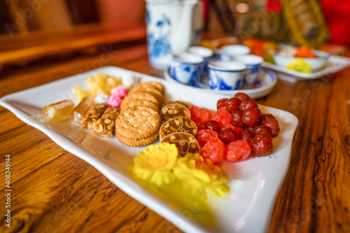 View of Vietnamese food for Tet holiday in spring, jam is traditional food and teapot set on lunar new year. Dried fruit and jam as tradition dessert - Mut Tet on wooden table. photo