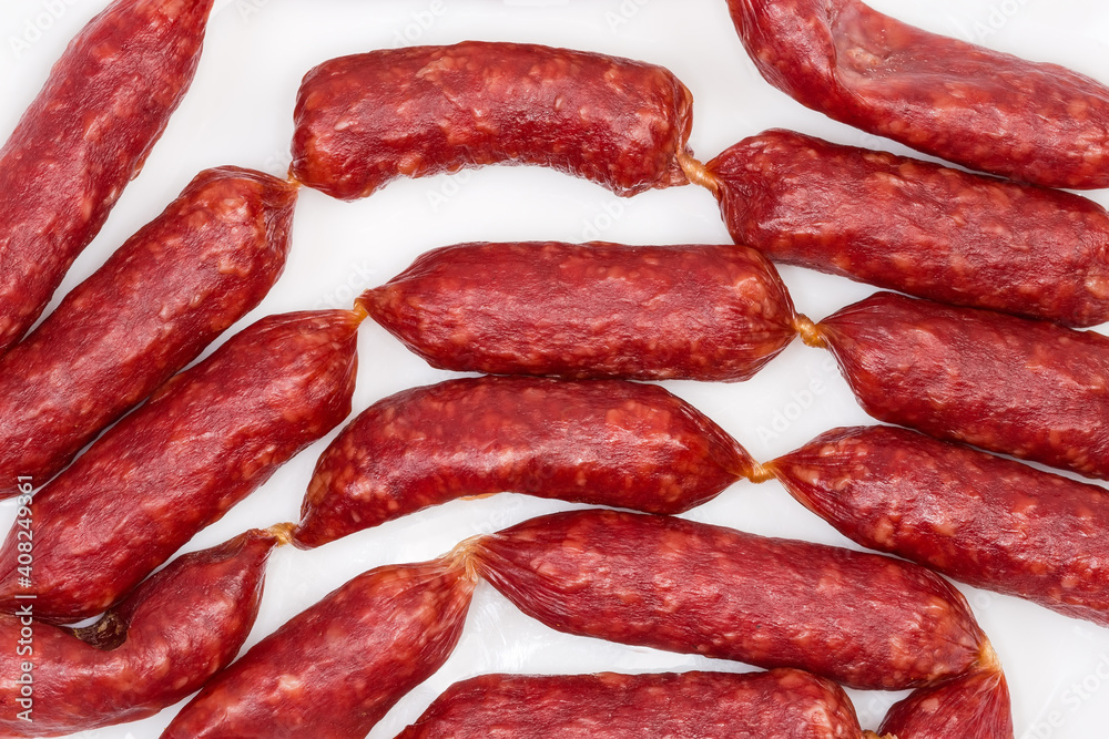 Background of small thin dry cured sausages, fragment top view Background of small thin dry cured sausages, fragment top view