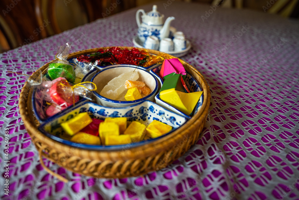 View of Vietnamese food for Tet holiday in spring, jam is traditional food and teapot set on lunar new year. Dried fruit and jam as tradition dessert - Mut Tet on wooden table.