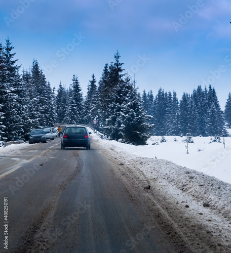 Winter Landscape with car , big fir trees covered snow