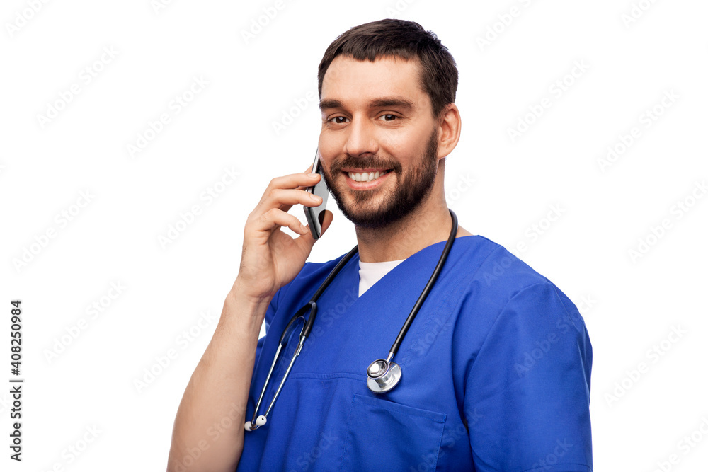 healthcare, profession and medicine concept - happy smiling doctor or male nurse in blue uniform with stethoscope calling on smartphone over white background healthcare, profession and medicine concept - happy smiling doctor or male nurse in blue uniform with stethoscope calling on smartphone over white background
