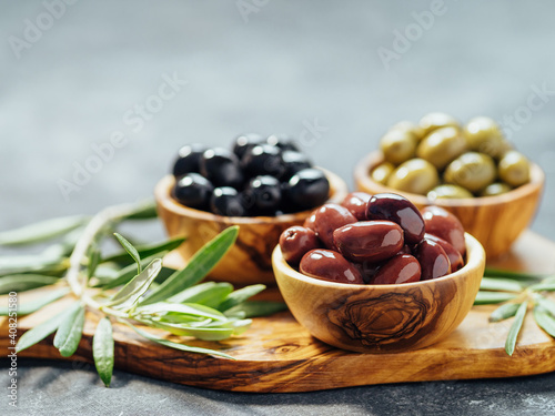 Fotografie Set of green, red and black olives on gray background