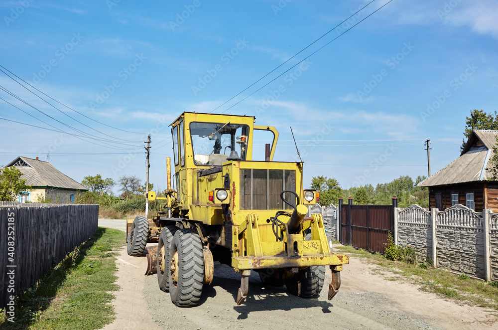 Obraz premium Road grader - heavy earth moving road construction equipment