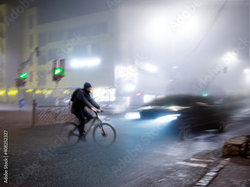Fototapeta Naklejka Na Ścianę i Meble -  Cyclist on zebra crossing in the evening. Dangerous situation