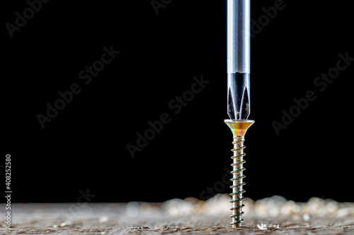 Obraz na plátně The screw and screwdriver close up on black background