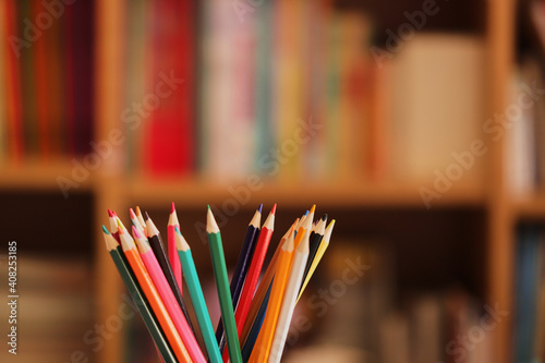 カラフルな色鉛筆と本棚の本の様子