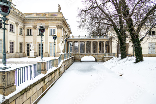historic palace on the water in   azienki Kr  lewskie park in Warsaw  Poland during snowy winter