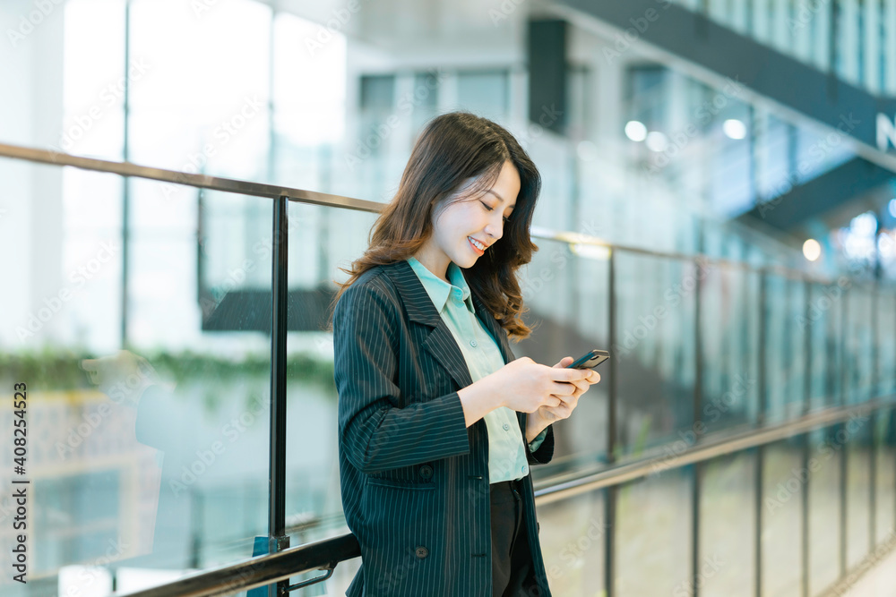 Fototapeta premium Portrait of a young Asian female director holding a phone