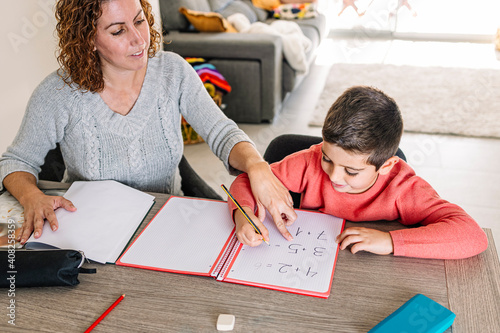 Mother helping his son to do maths at home