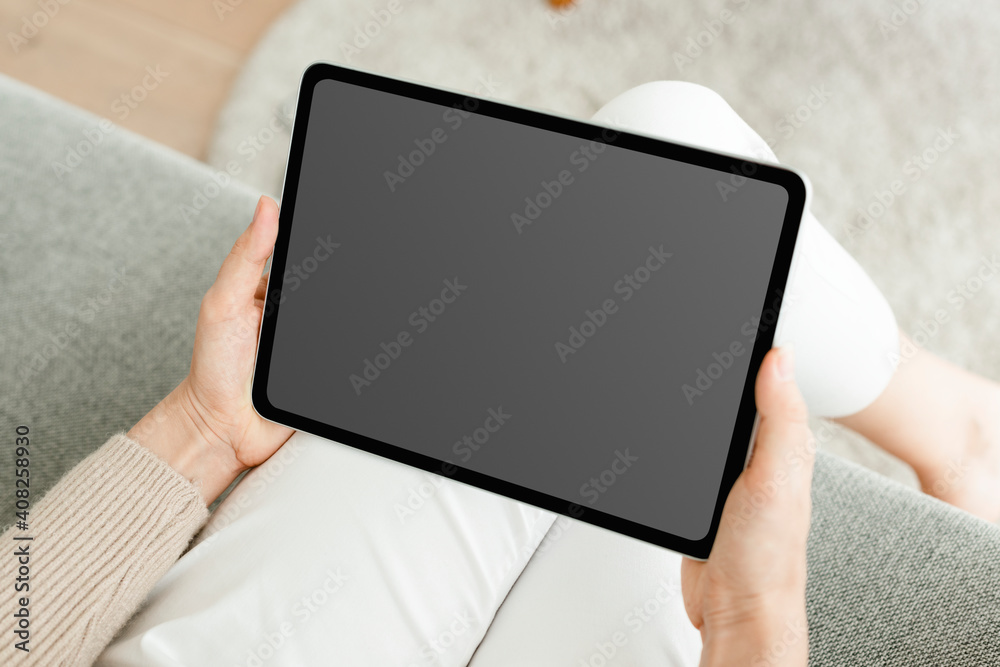 Hand holding digital tablet with blank black screen