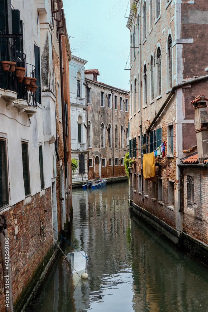 Venetian canal with a sunken boat. view from the bridge to the connection of two channels