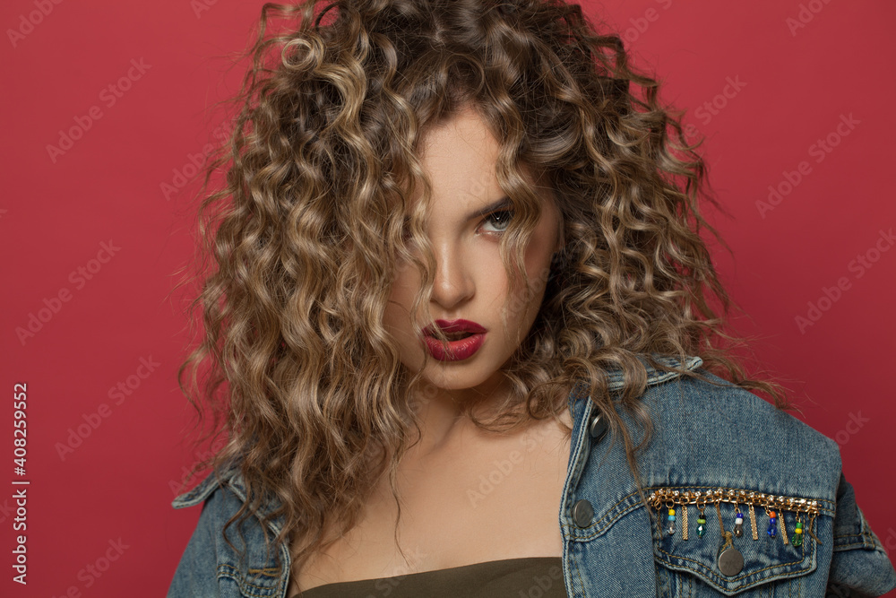 Fototapeta premium Perfect fashion model woman with curly hairstyle on red background