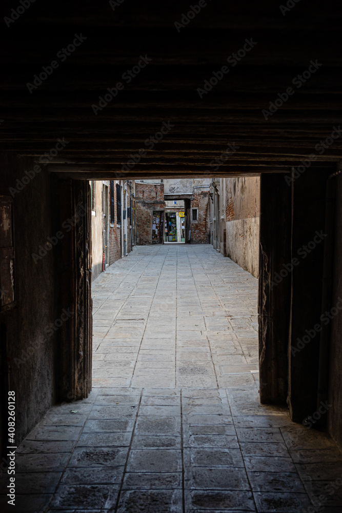 low ceiling of the entrance to one of the streets of venice. cobbled pedestrian street