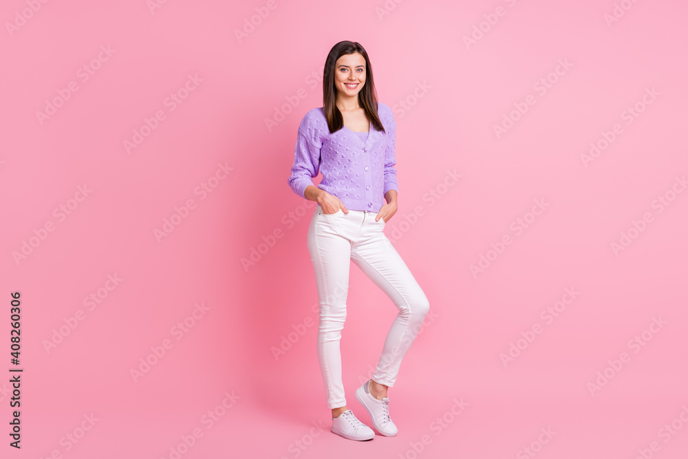 Full size photo of optimistic girl stand wear lilac sweater trousers sneakers isolated on pink color background Full size photo of optimistic girl stand wear lilac sweater trousers sneakers isolated on pink color background