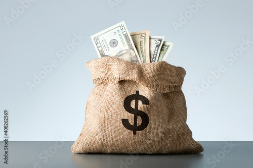 Burlap with dollar banknotes on gray background. Bribe or bonus concept. photo