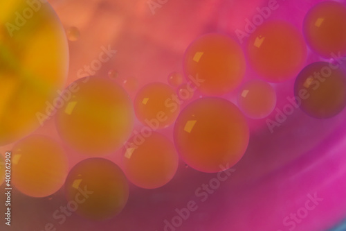 Blurred soft focus of oil spheres in water with color transition from orange to purple tones for colorful background