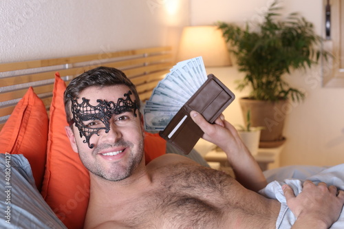 Billede på lærred Very attractive man in bed with full wallet