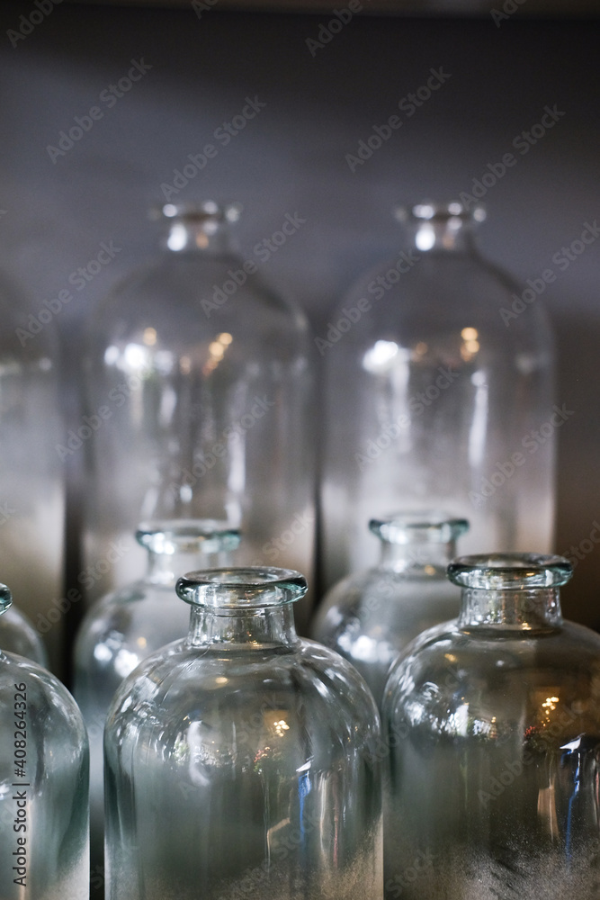 Decorative glass bottles on a shelf. Blue background Decorative glass bottles on a shelf. Blue background