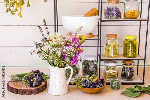 Canvastavla Lot of various herbal medicinal plants gathered and drying in room and dried herbs in glass jars on shelf