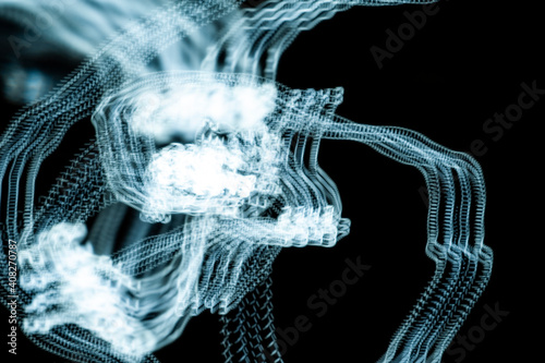An abstraction. Numbers in motion. Turquoise on a black background. Dark background.