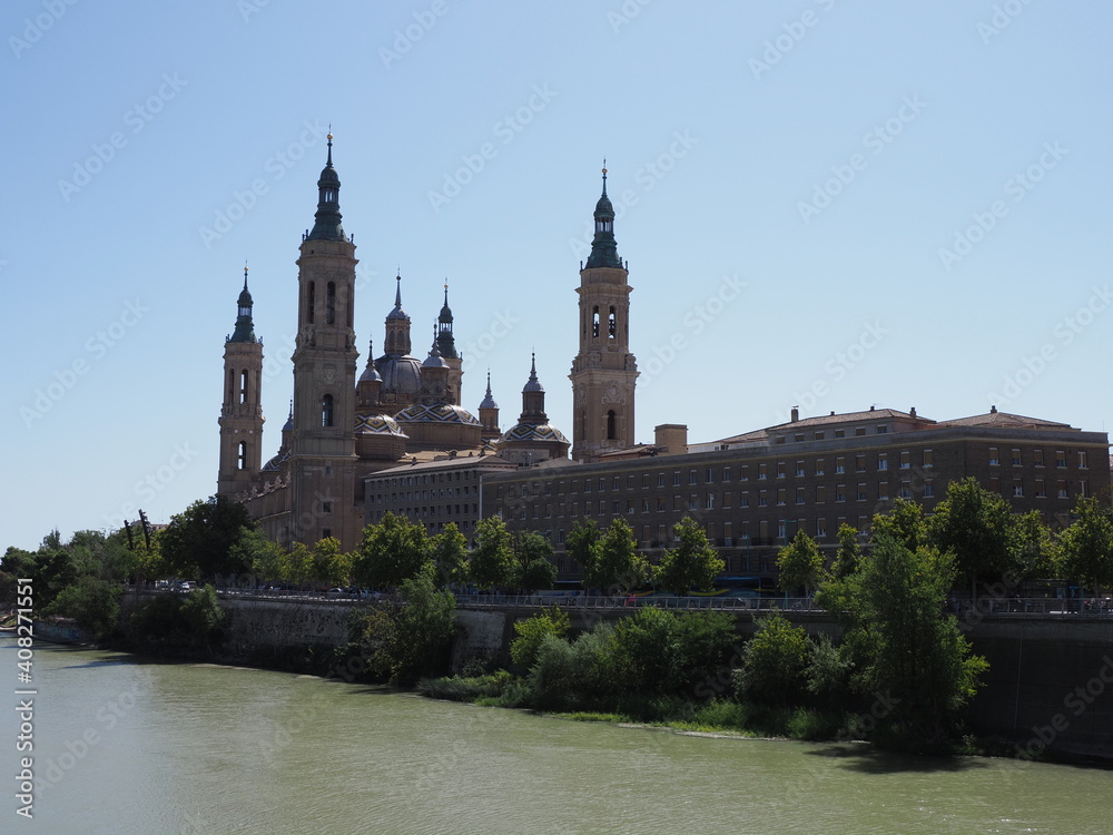 Great basilica of our lady of the Pillar and Ebro river in european Saragossa city at Aragon district in Spain, clear blue sky in 2019 warm sunny summer day on September.