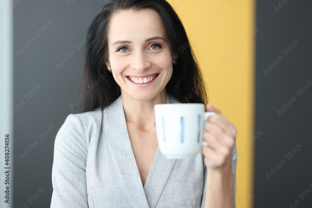 Portrait of smiling woman holding cup in her hand Portrait of smiling woman holding cup in her hand