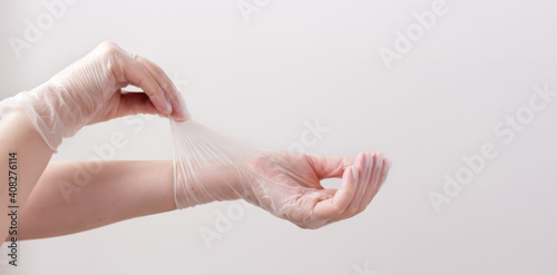Feminine hands in transparent vinyl gloves