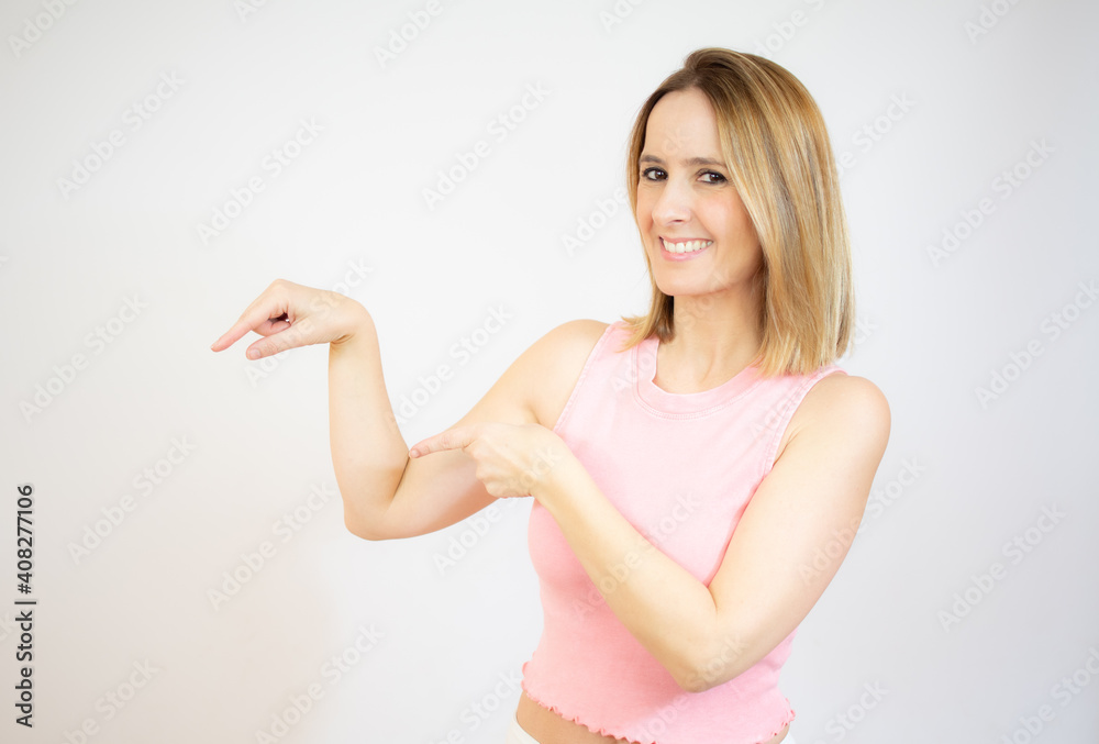Smiling young woman over isolated white background pointing finger to the side Smiling young woman over isolated white background pointing finger to the side