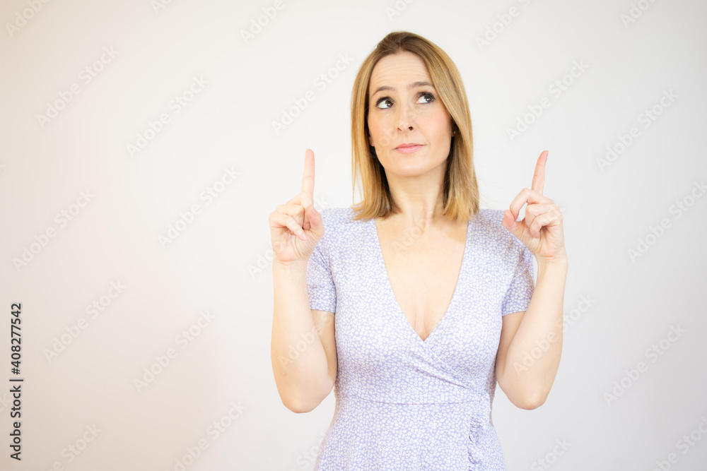 Young woman pointing up with both index fingers standing over white background. Young woman pointing up with both index fingers standing over white background.
