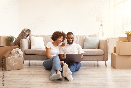 Black Couple Using Laptop Sitting Indoor After Moving New Home