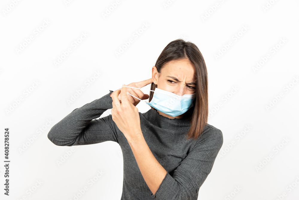 Hispanic woman with pain behind ears caused by the earloop of the medical face mask. Healthcare during Coronavirus pandemic concept. Hispanic woman with pain behind ears caused by the earloop of the medical face mask. Healthcare during Coronavirus pandemic concept.