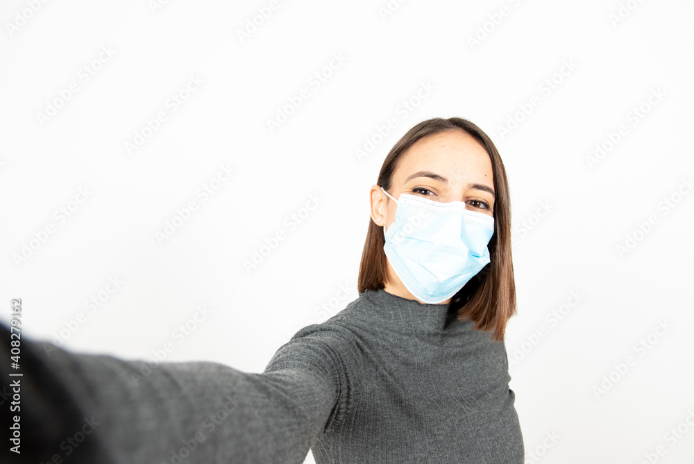 Closeup portrait of a positive latin woman with a medical face mask taking a selfie. Healthcare during Coronavirus pandemic concept. Closeup portrait of a positive latin woman with a medical face mask taking a selfie. Healthcare during Coronavirus pandemic concept.