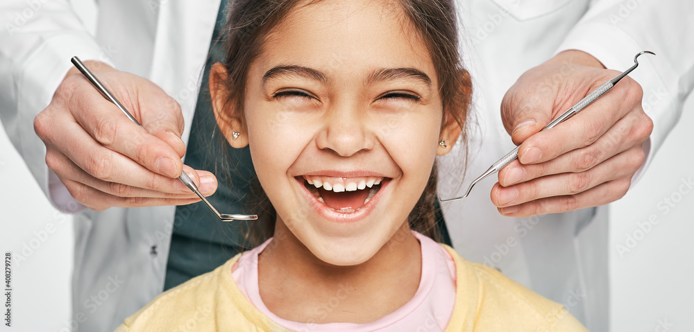 Smiling mixed race girl in a dental clinic for children. Child with a